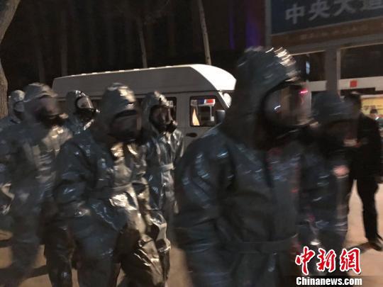 十几名身着防护服的人员头戴面具进入事发地。　胡健 摄